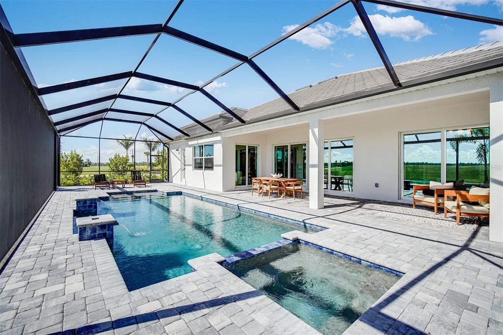 A screened-in patio features a swimming pool, a hot tub, and outdoor dining furniture — 18939 CHERRYSTONE WAY, LAKEWOOD RANCH, FL