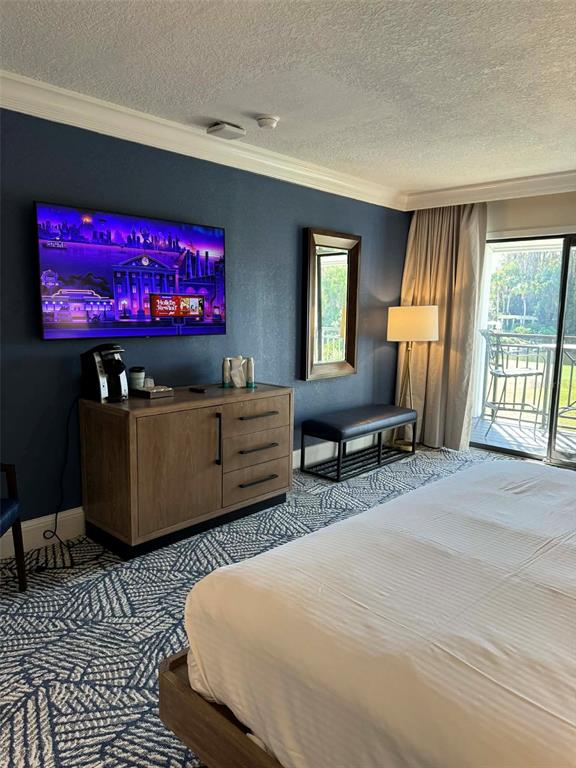 A hotel room features a bed, a wooden dresser, a wall-mounted television, and a balcony — 4762 FOX HUNT DRIVE UNIT A304 & A302, WESLEY CHAPEL, FL
