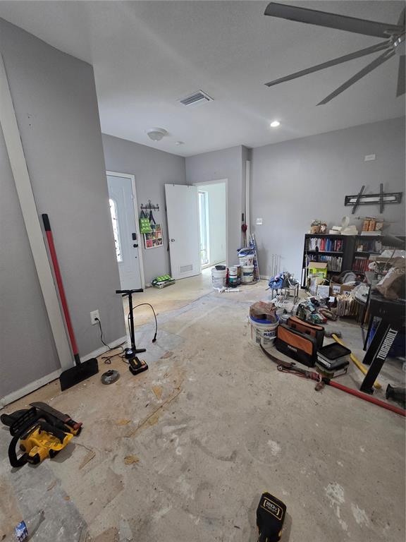 An unfinished room with exposed concrete flooring, gray walls, and various construction tools and supplies — 908 GRAND CENTRAL STREET, CLEARWATER, FL