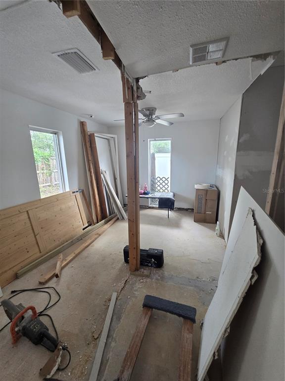 An unfinished room under renovation features exposed ceiling framing, a central support post, and drywall — 908 GRAND CENTRAL STREET, CLEARWATER, FL