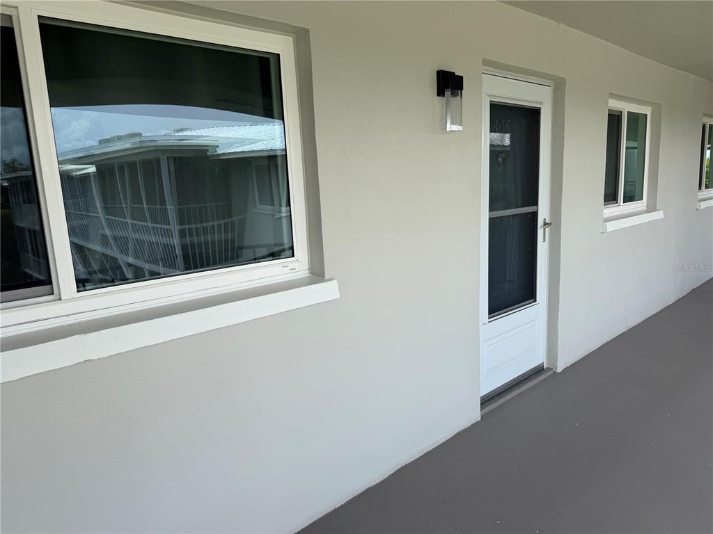 A white exterior wall features a large window, a door labeled 305, and a walkway — 649 TAMIAMI TRAIL S UNIT 305, VENICE, FL