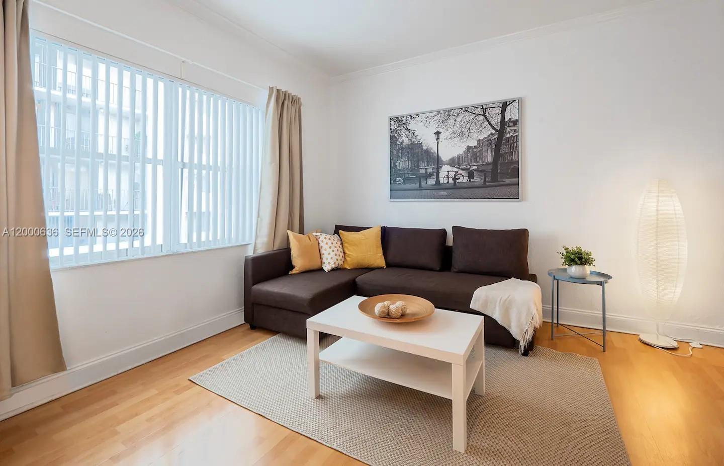A living room features a brown sectional sofa, a white coffee table, and a floor lamp — 2615 Collins Ave # 37, Miami Beach FL 33140, MIAMI BEACH, FL