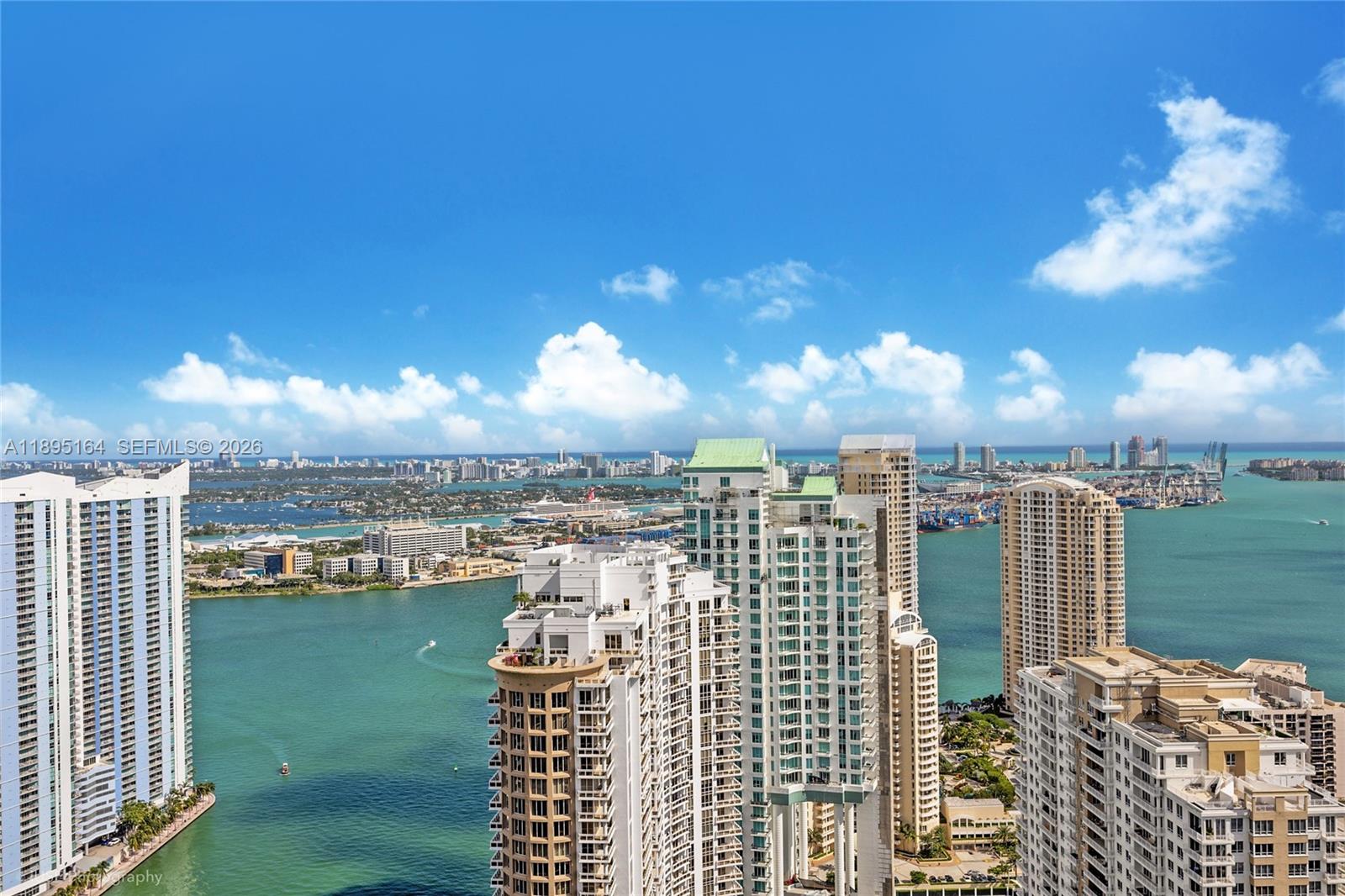 An elevated view of high-rise apartment buildings overlooking a bay and city skyline — 495 Brickell Ave # 4710, Miami FL 33131, MIAMI, FL