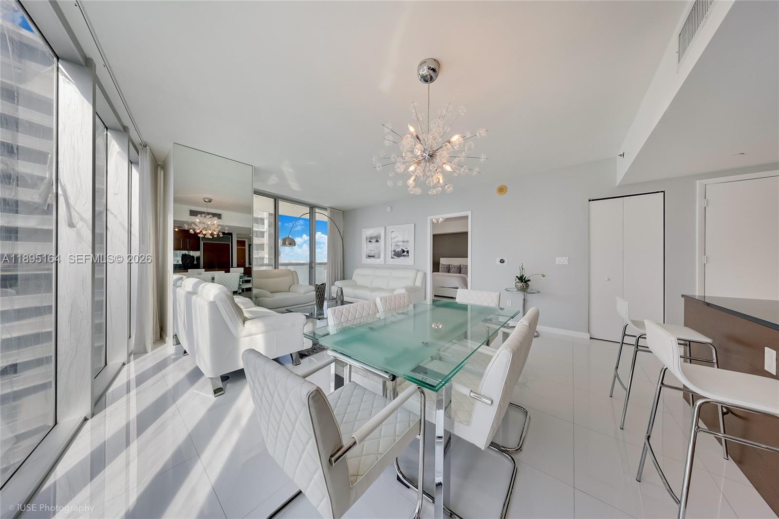 A bright dining and living area features white furniture, a glass table, and floor-to-ceiling windows — 495 Brickell Ave # 4710, Miami FL 33131, MIAMI, FL
