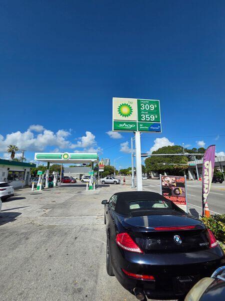 A black convertible is parked at a BP gas station under a clear blue sky — 3198 S Dixie Highway, Miami FL 33133, MIAMI, FL