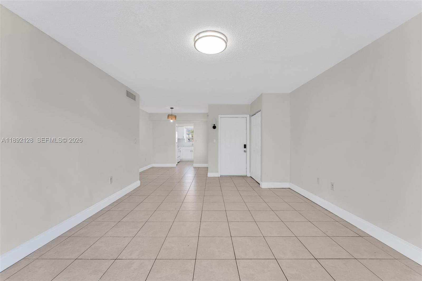 An empty room with light-colored walls, tiled floors, a ceiling light, and a white door — 7330 SW 82nd St # B218, Miami FL 33143, MIAMI, FL