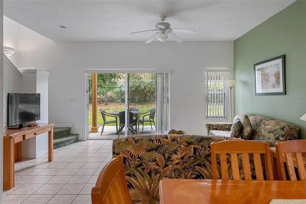 A kitchen features oak cabinets, a white microwave and stove, and a tan countertop — 1055 PARK RIDGE CIRCLE, KISSIMMEE, FL