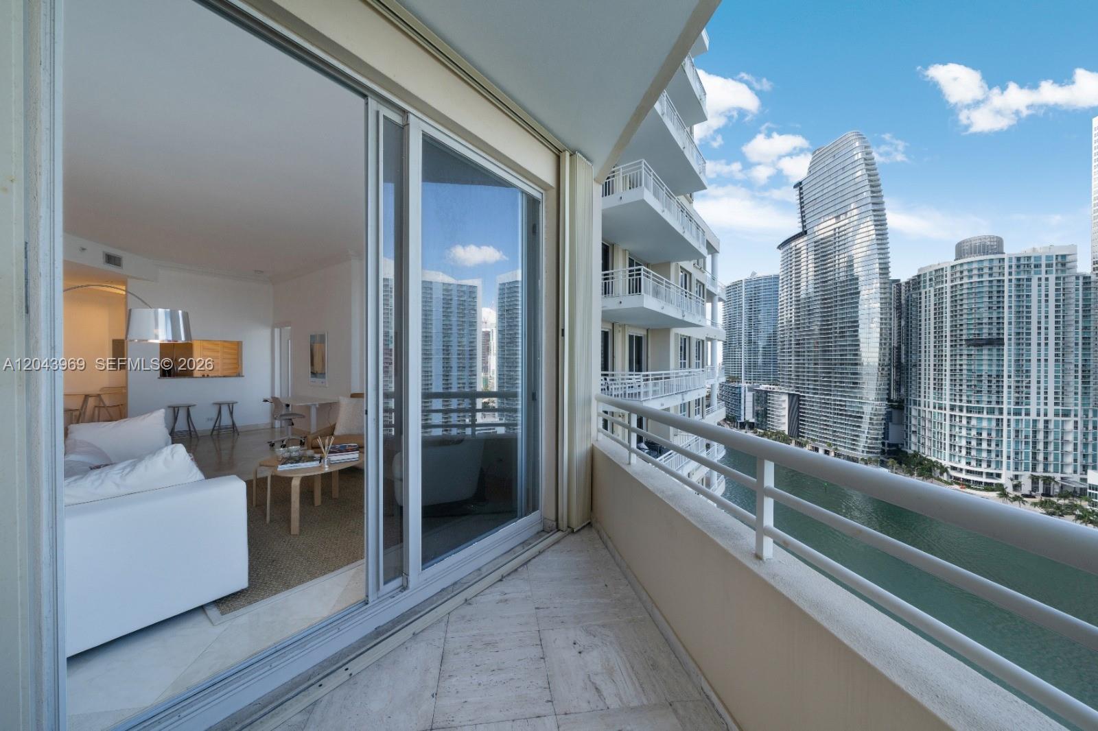 A balcony with marble flooring overlooks a canal and high-rise buildings in a city — 888 Brickell Key Dr # 2610, Miami FL 33131, MIAMI, FL