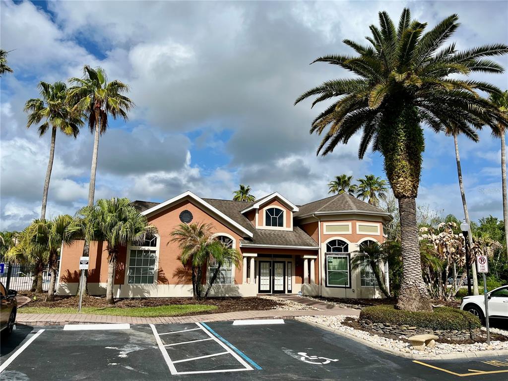 A single-story building with a tan stucco exterior and a palm-lined parking lot — 1939 SUMMER CLUB APT DRIVE UNIT 315, OVIEDO, FL