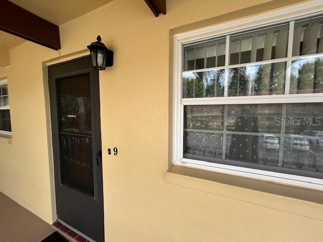 A beige exterior wall features a dark storm door with the number 9 and a window — 1845 S HIGHLAND AVENUE UNIT 4-9, CLEARWATER, FL