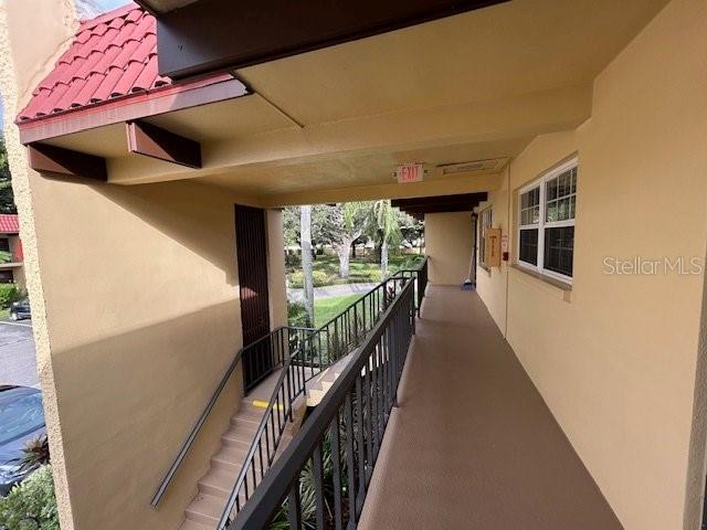 An outdoor walkway with stairs leads to an apartment entrance under a covered building overhang — 1845 S HIGHLAND AVENUE UNIT 4-9, CLEARWATER, FL