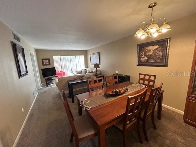 A dining area with a wooden table and chairs sits in front of a living room — 1845 S HIGHLAND AVENUE UNIT 4-9, CLEARWATER, FL
