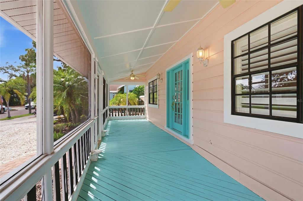 A screened-in porch with light blue wooden flooring and a bright turquoise front door — 345 BAILEY STREET, SAFETY HARBOR, FL