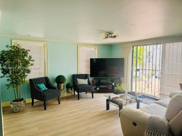 A living room features light blue walls, a beige sofa set, and a mirrored wall — 635 NW 97th Pl, Miami FL 33172, MIAMI, FL