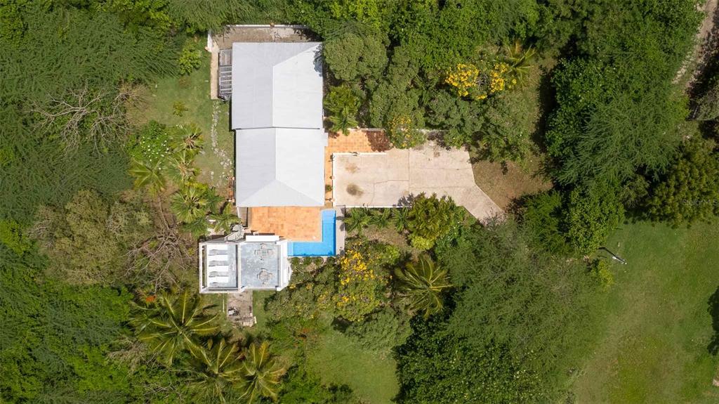 An aerial view shows a house with a metal roof, swimming pool, and surrounding trees — 20 CALLE RAMOS RIVERA, VIEQUES, PR