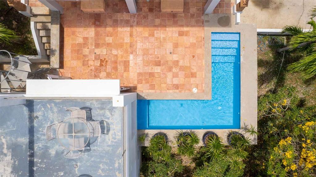 An aerial view shows an L-shaped swimming pool adjacent to a tiled patio and terrace — 20 CALLE RAMOS RIVERA, VIEQUES, PR
