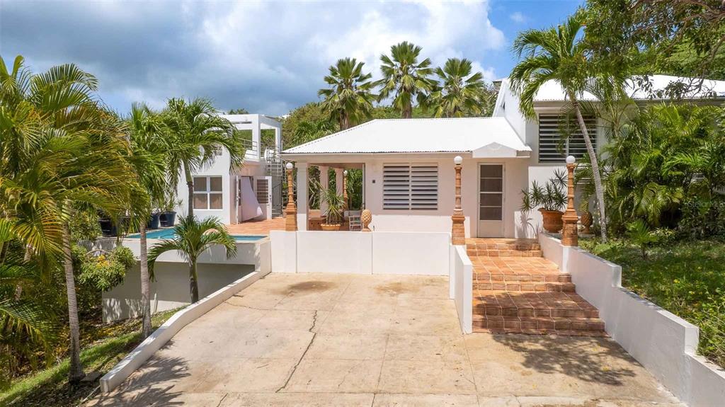 A white house with a concrete driveway, brick steps, and an adjacent swimming pool — 20 CALLE RAMOS RIVERA, VIEQUES, PR