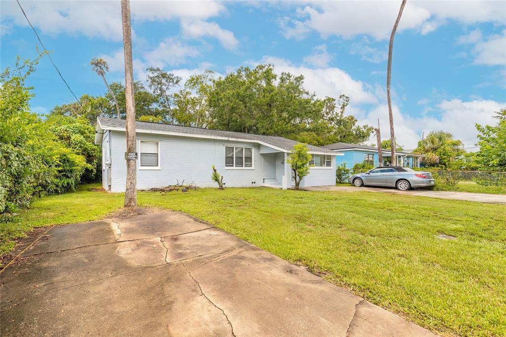 A light blue, single-story house with a cracked concrete driveway and two palm trees — 730 FLANDERS AVENUE, DAYTONA BEACH, FL