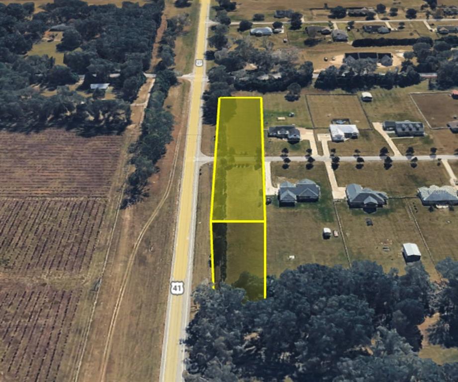 An aerial view shows a rectangular plot of land highlighted in yellow along a highway — 0 NW 143RD ROAD, HIGH SPRINGS, FL