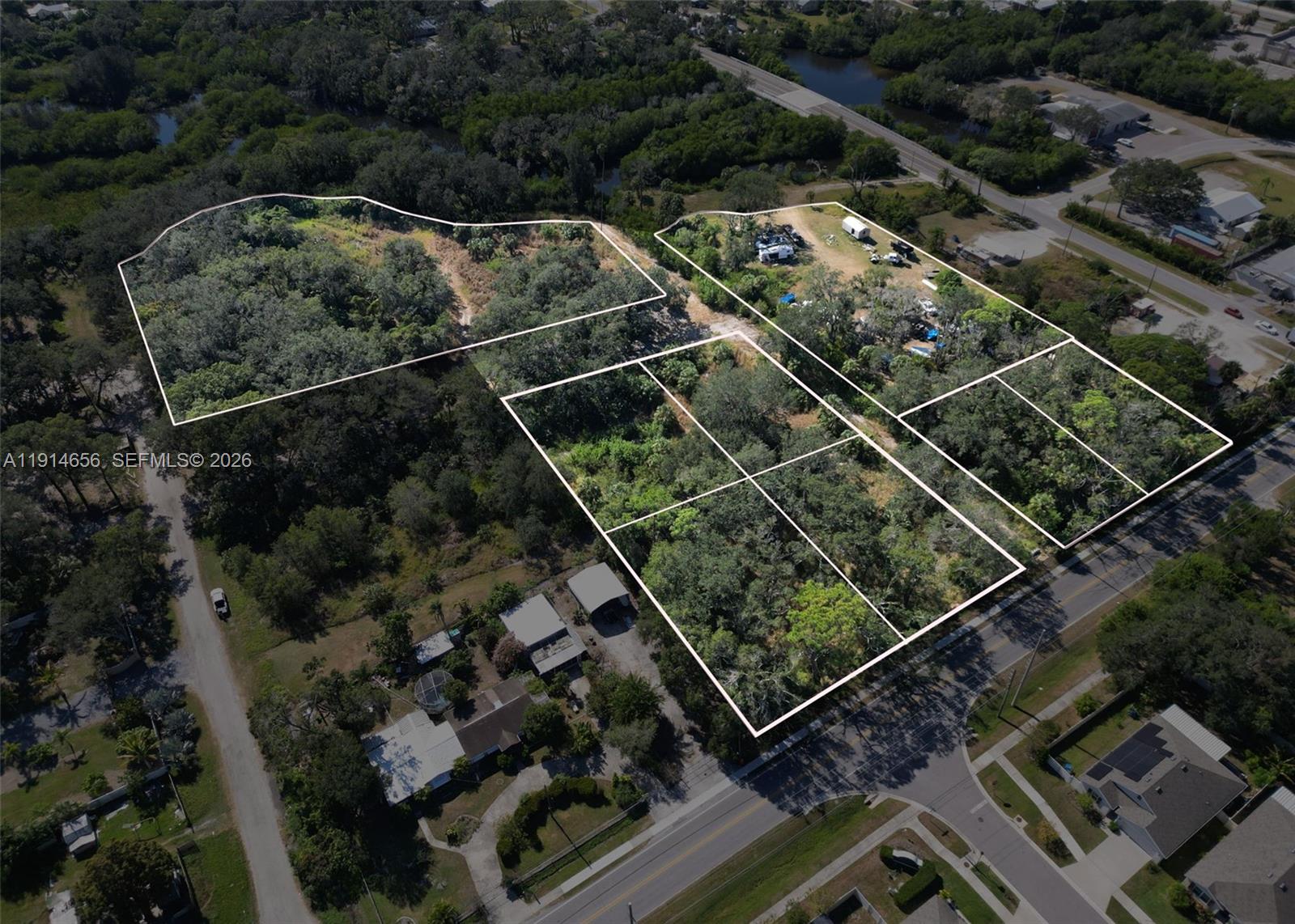 An aerial view shows several wooded land parcels outlined in white near a paved road — 301 E Shell Point Road, Tampa FL 33570, TAMPA, FL