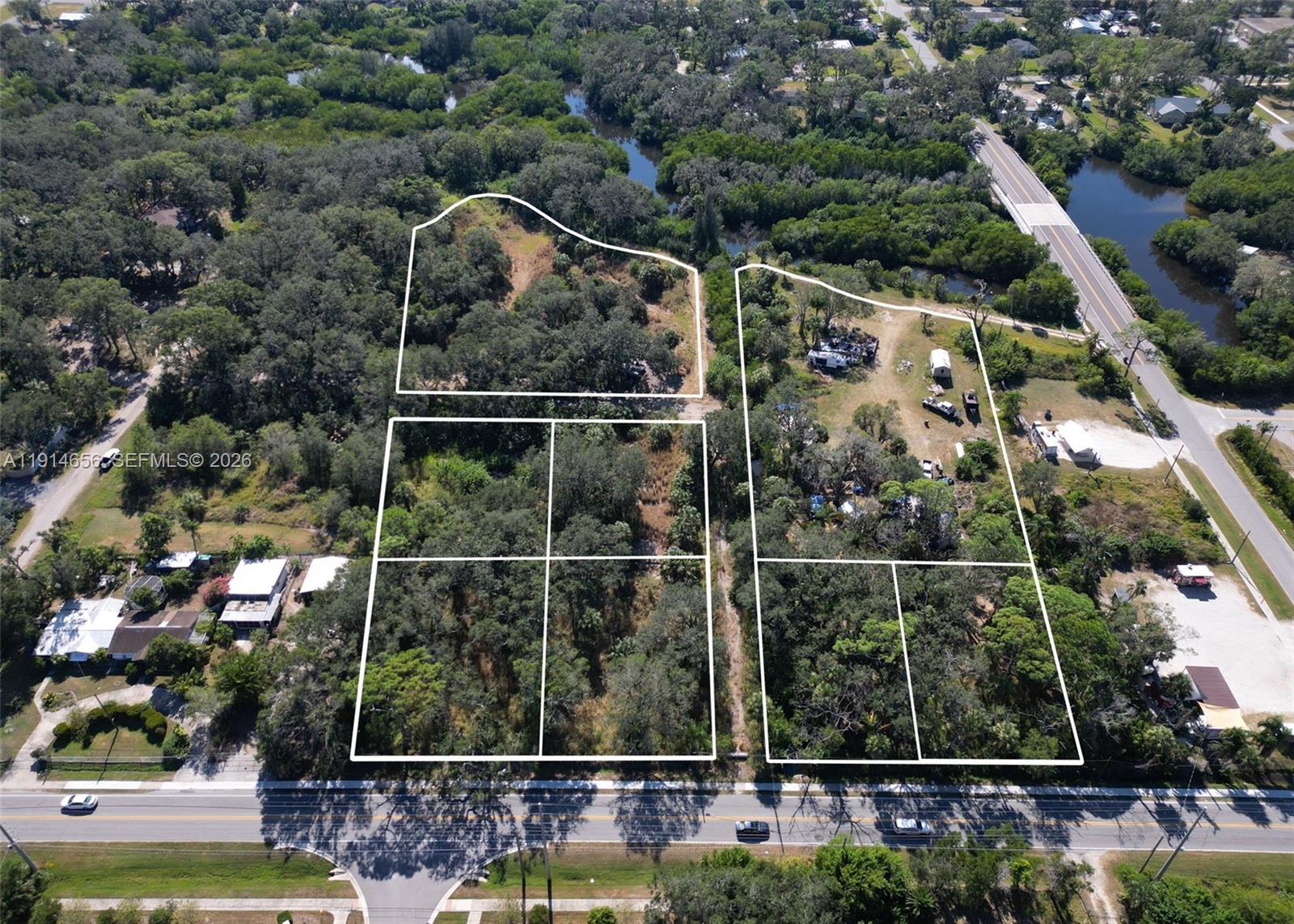 This aerial view shows several adjacent wooded lots outlined in white along a road — 301 E Shell Point Road, Tampa FL 33570, TAMPA, FL