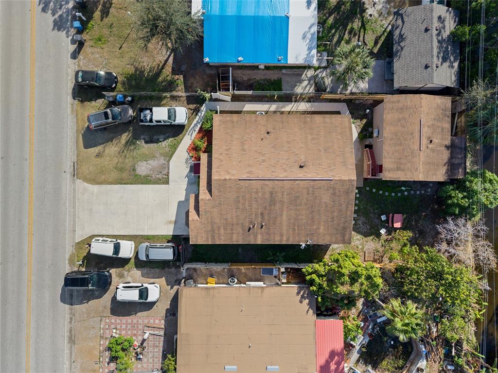 An aerial view shows a residential property with a brown roof, driveway, and parked cars — 4704 TOWN N COUNTRY BOULEVARD, TAMPA, FL