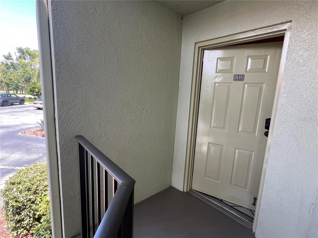 An exterior view of a building entrance with a beige door labeled B15 — 1515 PINELLAS BAYWAY S UNIT 15, TIERRA VERDE, FL