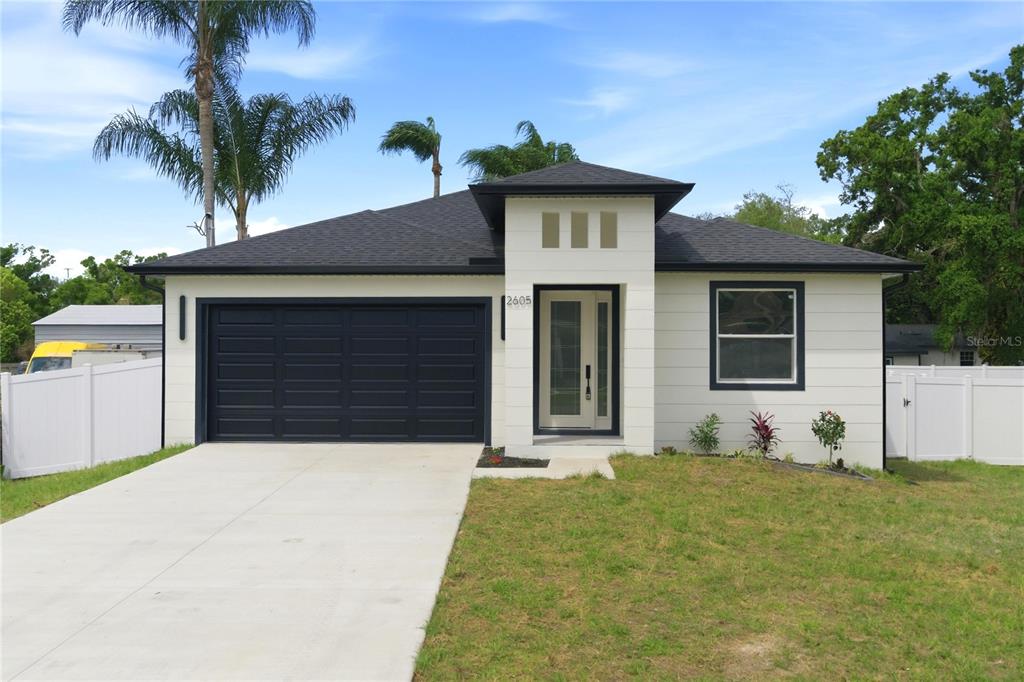 A single-story house with a white exterior, dark roof, and a front-facing garage — 2605 S 70TH STREET, TAMPA, FL