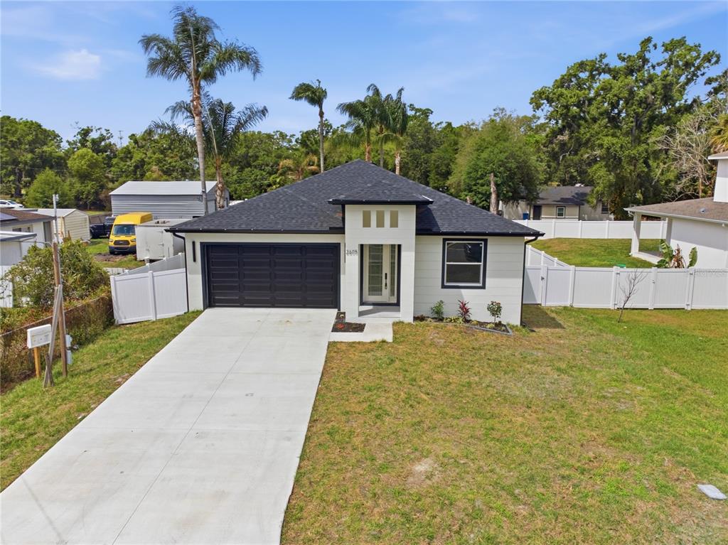A single-story house with a black roof, white siding, and a concrete driveway — 2605 S 70TH STREET, TAMPA, FL