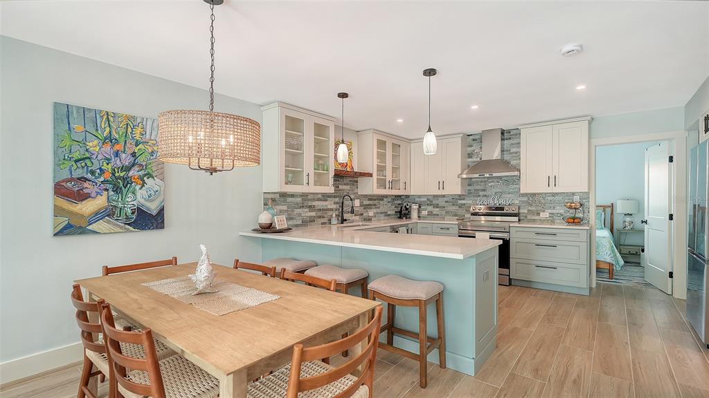 A kitchen with light blue cabinets, a breakfast bar, and an adjacent dining area — 4720 GULF OF MEXICO DRIVE UNIT Villa 2, LONGBOAT KEY, FL