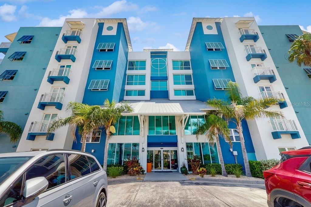 The exterior of a multi-story blue and white apartment building with a central entrance — 611 S ATLANTIC AVENUE UNIT 4512, NEW SMYRNA BEACH, FL