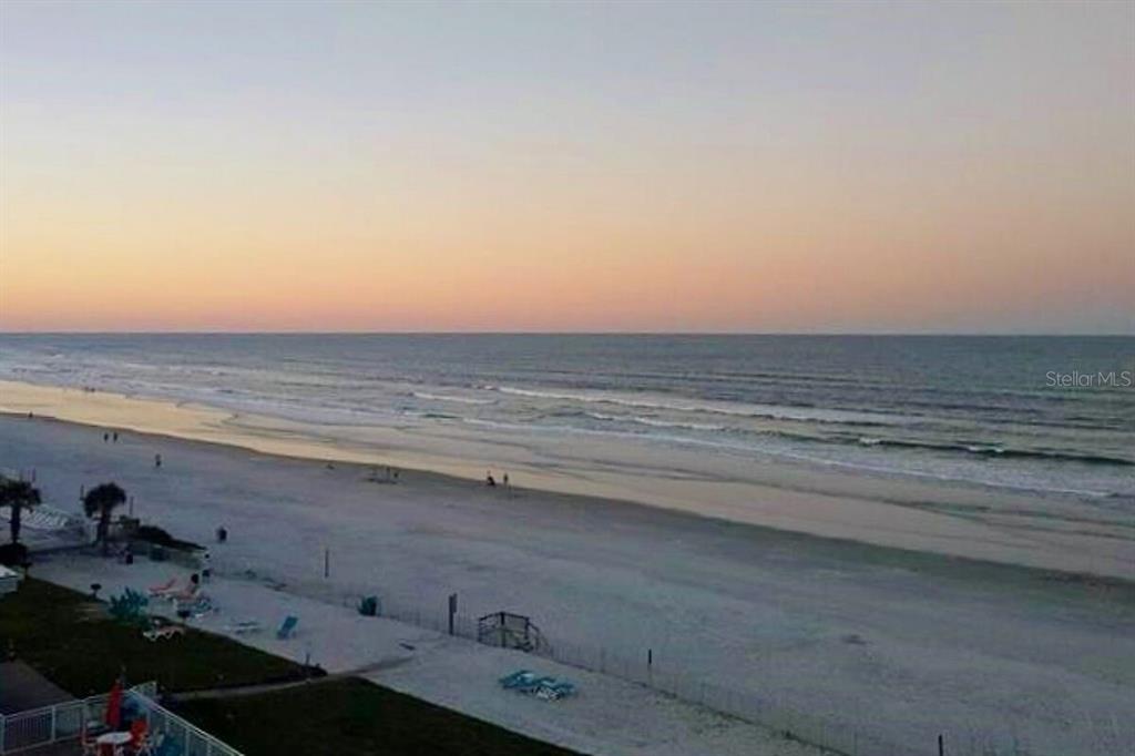 An elevated view of a sandy beach and the ocean at sunset — 611 S ATLANTIC AVENUE UNIT 4512, NEW SMYRNA BEACH, FL