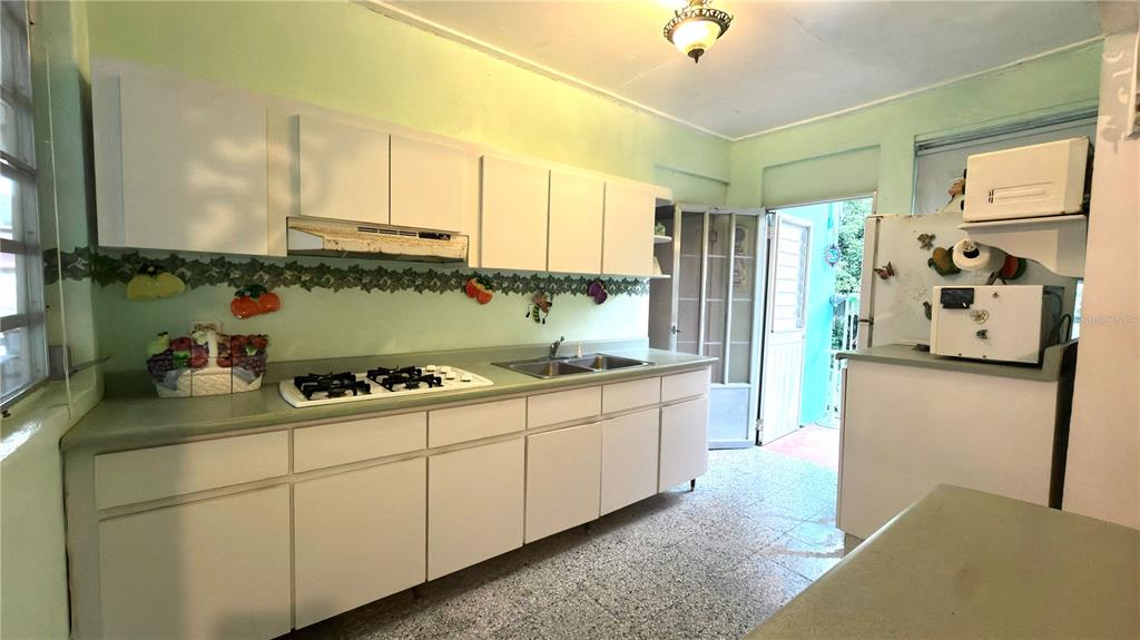 A kitchen features white cabinets, a light green countertop, and a tiled floor — . 123 KM 16.1 INT., PONCE, PR