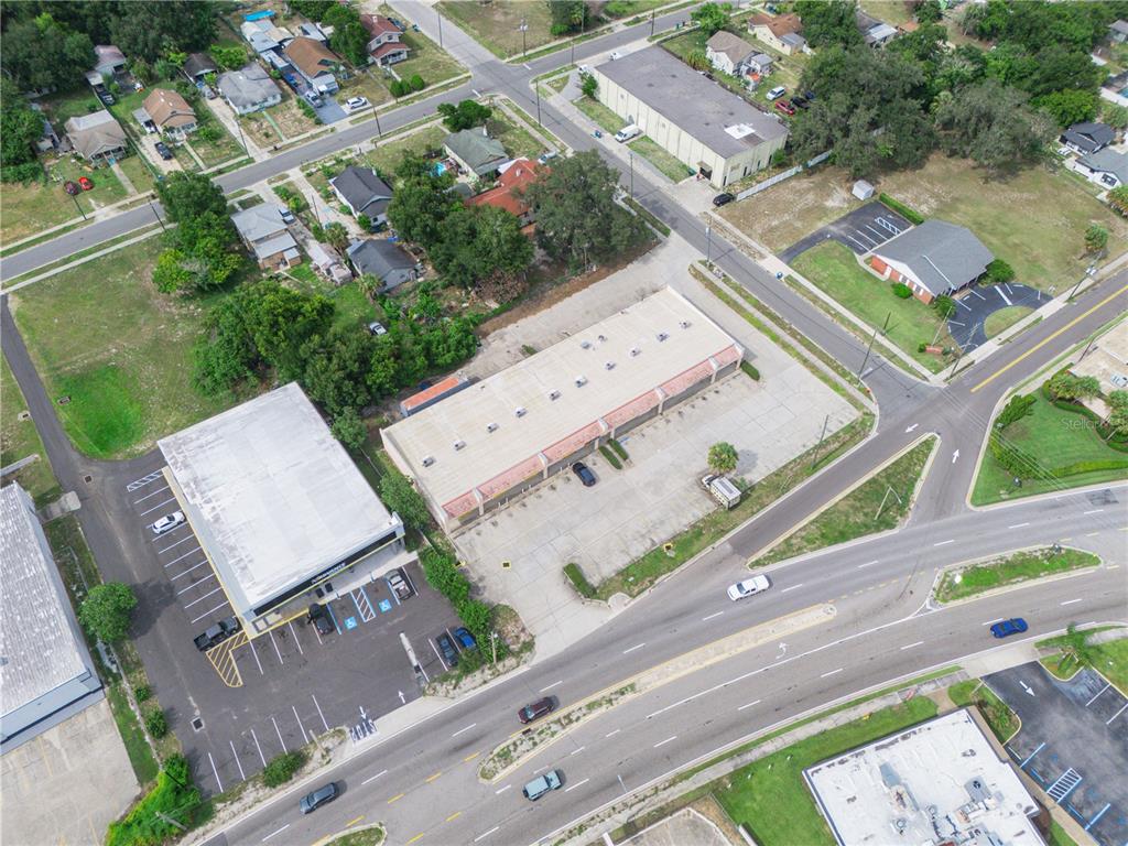 An aerial view shows commercial buildings with parking lots situated near a multi-lane road intersection — 104 STATE ROAD 60 W, LAKE WALES, FL