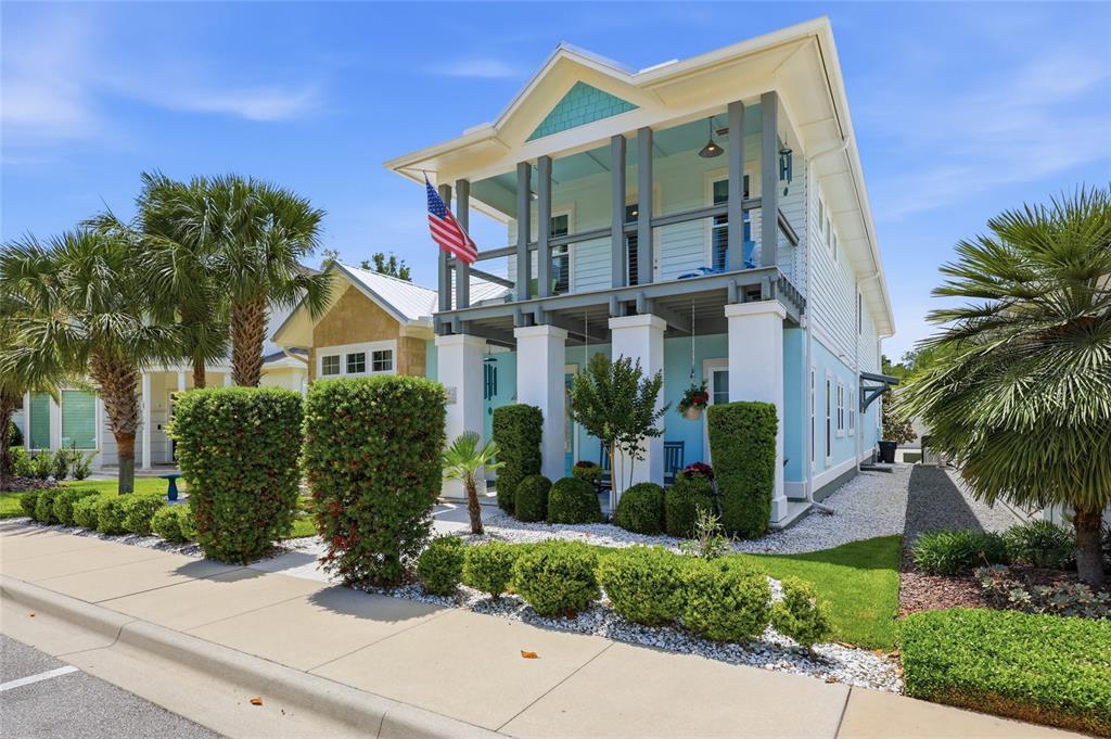 A two-story light blue house with a front porch, balcony, and manicured landscaping — 742 SW 132ND DRIVE, NEWBERRY, FL