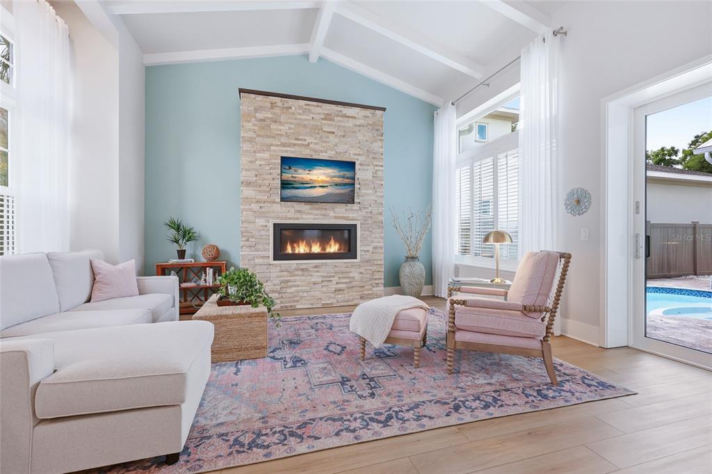 A living room features a stone fireplace, light blue accent wall, and a pink rug — 742 SW 132ND DRIVE, NEWBERRY, FL