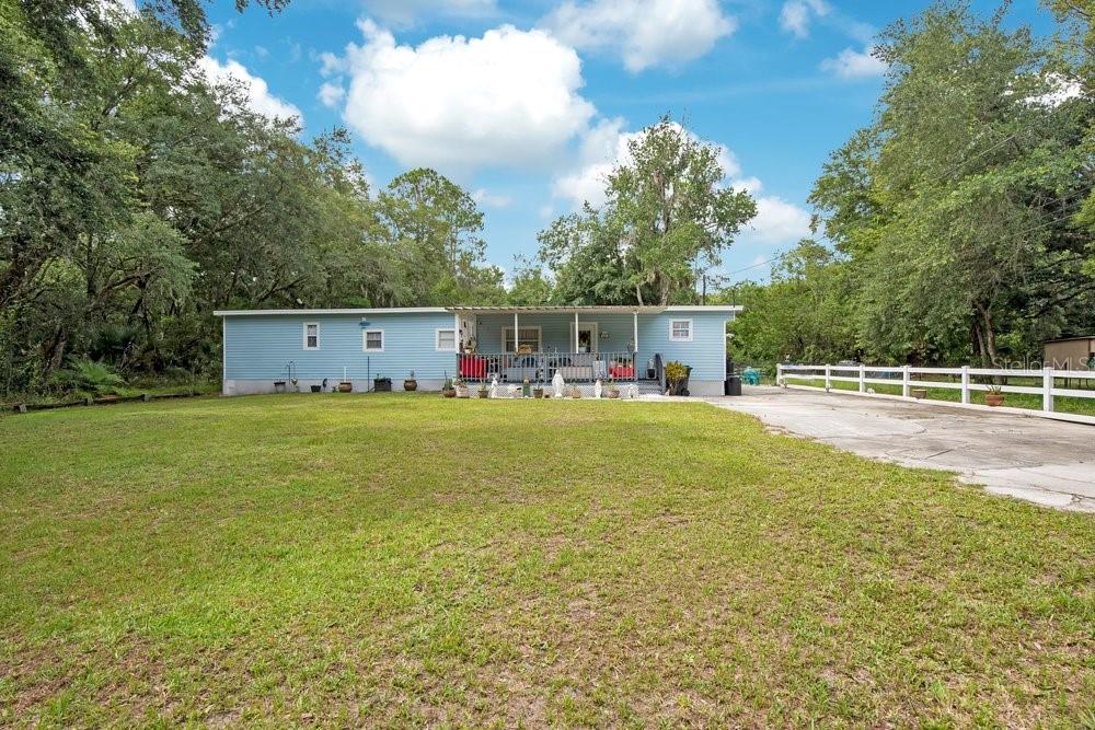A light blue single-story house with a covered front porch sits on a grassy lot — 18222 LYNBROOK ROAD, ORLANDO, FL