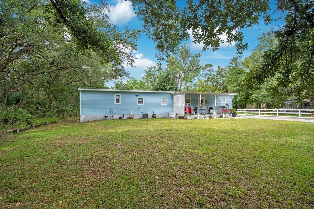 A light blue single-story home with a front porch sits on a grassy lot — 18222 LYNBROOK ROAD, ORLANDO, FL