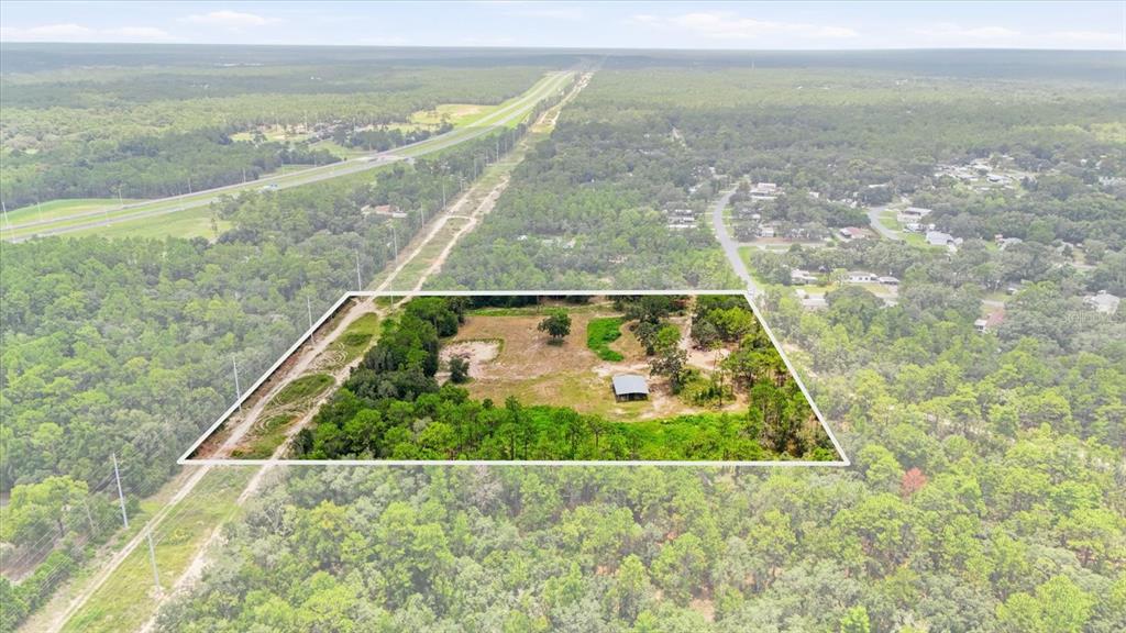 An aerial view shows a rectangular plot of land with a small structure and trees — 209 S SPICE WOOD TERRACE, LECANTO, FL