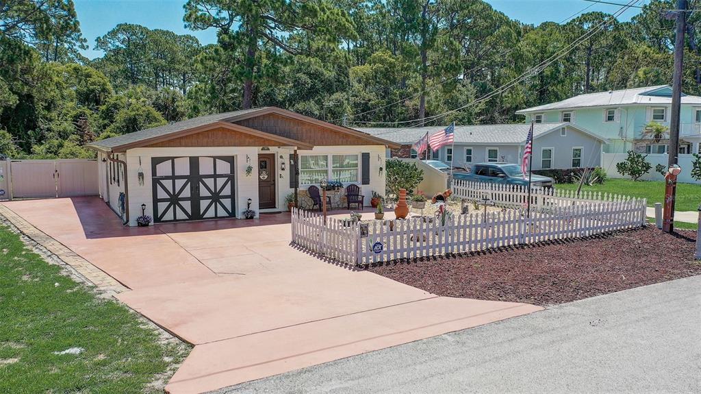 A single-story house with a white exterior, a garage, and a fenced front yard — 298 POINCIANA AVENUE, PORT ORANGE, FL