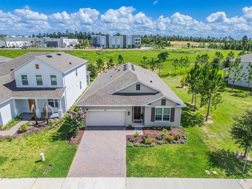 An aerial view shows a single-story suburban house with a paved driveway and grassy yard — 864 VINEYARD RIDGE ROAD, MINNEOLA, FL