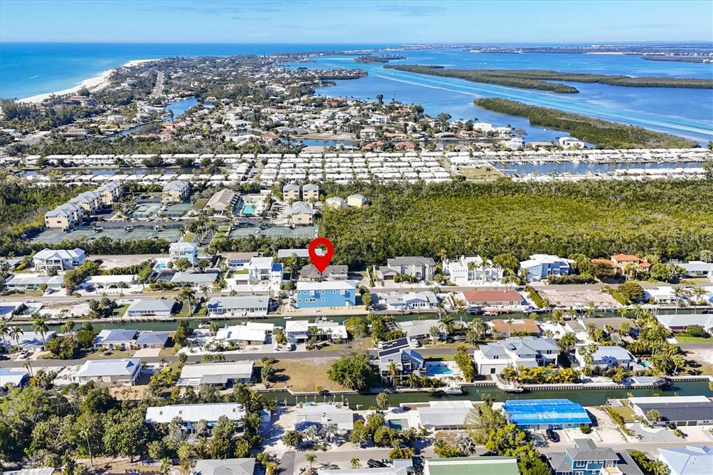 An aerial view shows a coastal neighborhood with houses, canals, and a red location marker — 651 JUNGLE QUEEN WAY, LONGBOAT KEY, FL
