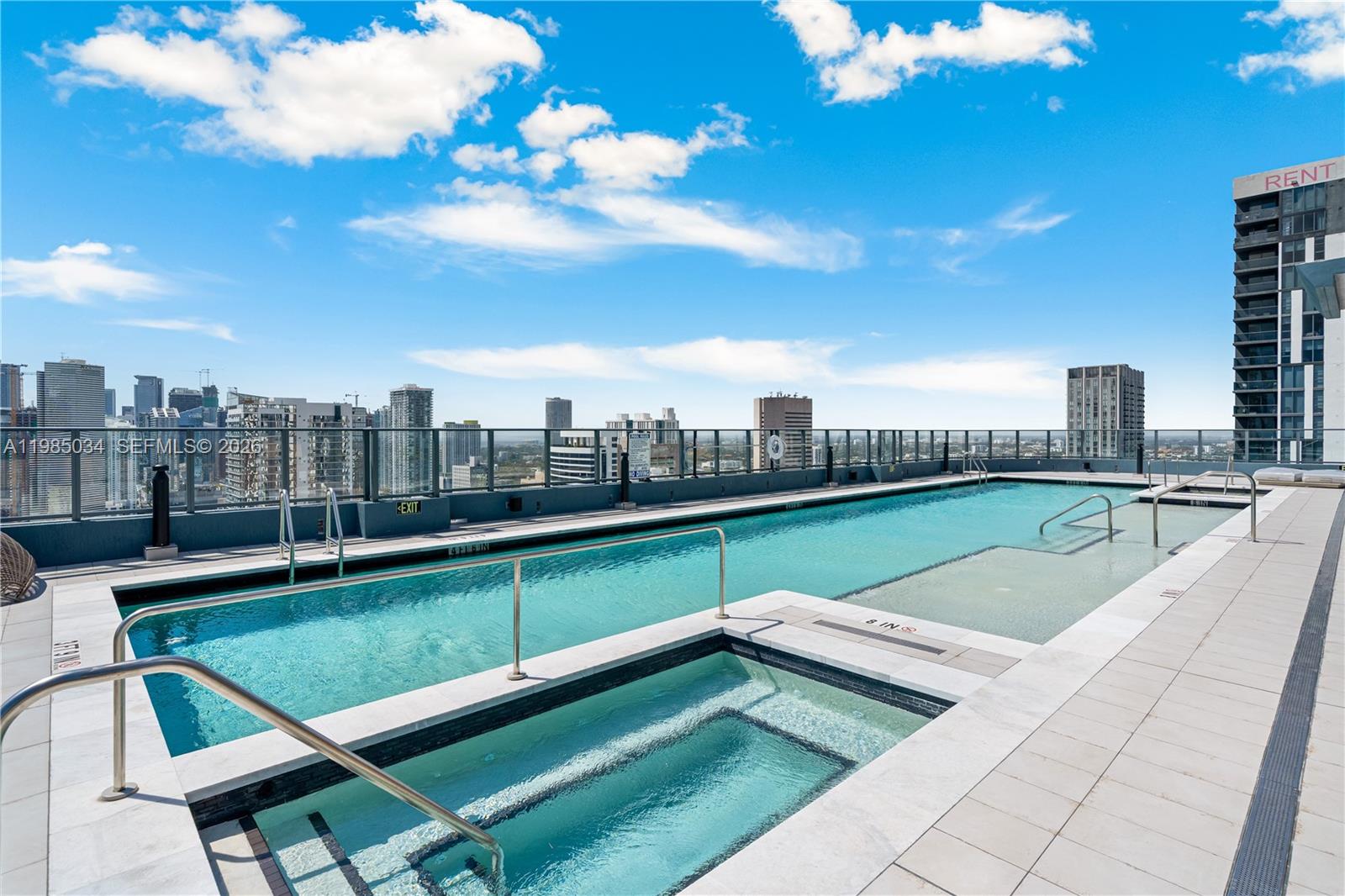A rooftop swimming pool and hot tub overlook a city skyline under a blue sky — 121 NE 5th St # 2706, Miami FL 33132, MIAMI, FL
