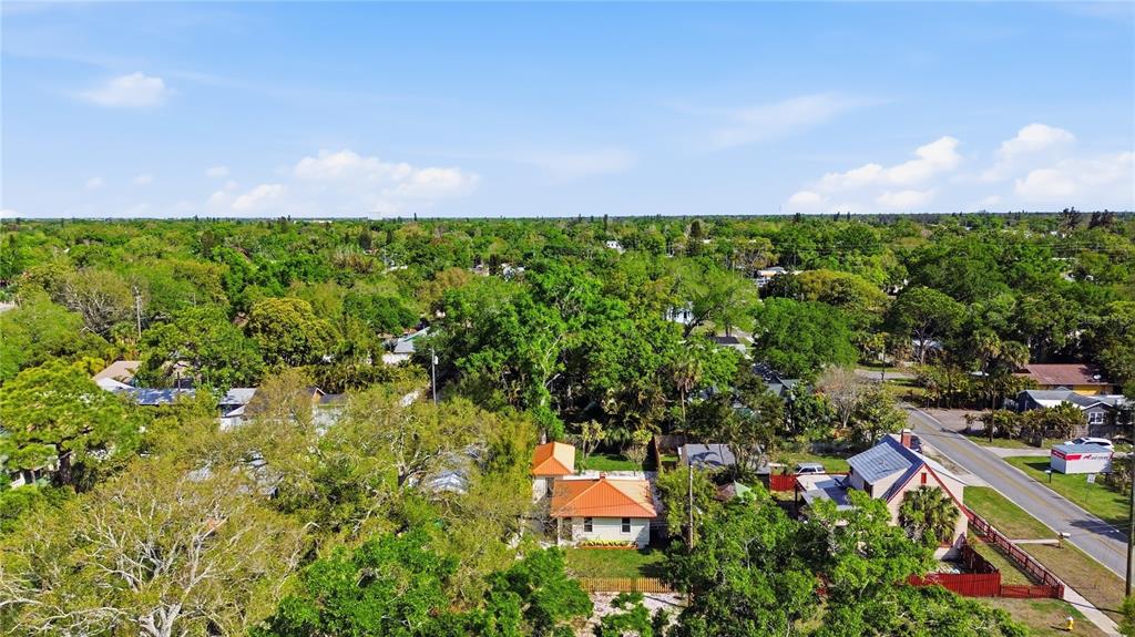 An aerial view shows a house with an orange roof surrounded by trees and greenery — 5211 25TH AVENUE S, GULFPORT, FL