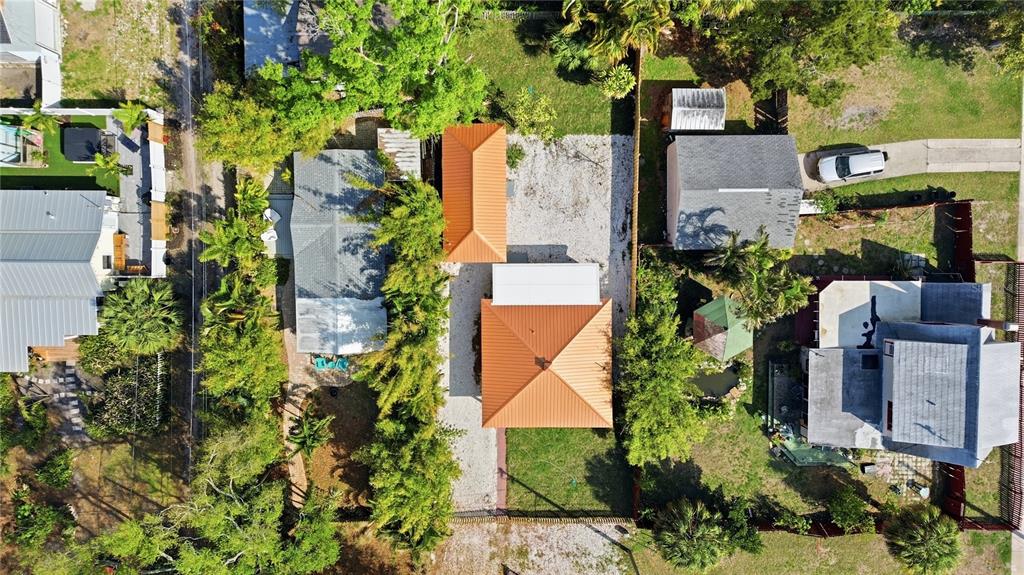 An aerial view shows two houses with orange metal roofs surrounded by trees and landscaping — 5211 25TH AVENUE S, GULFPORT, FL