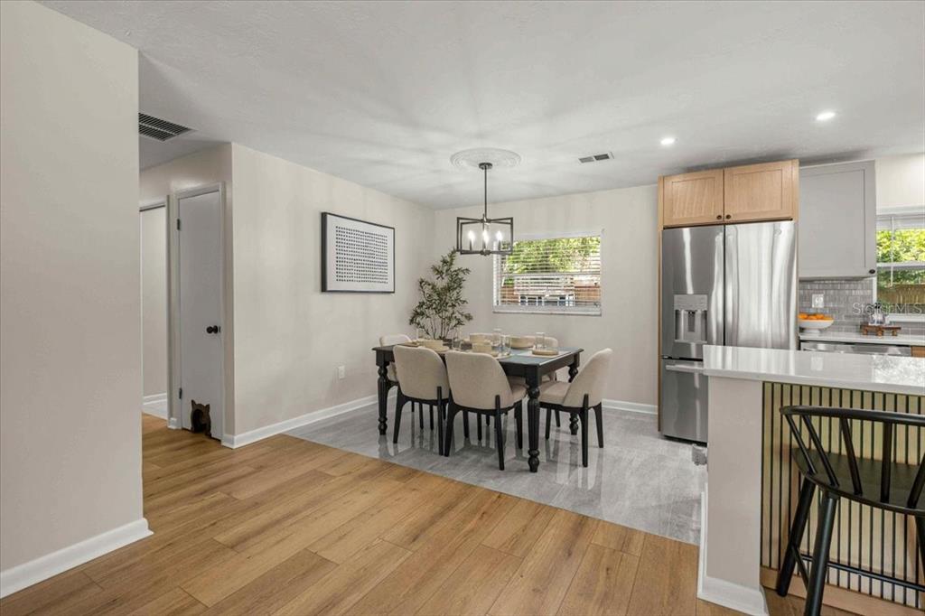 A dining area with a table, chairs, and light wood flooring adjacent to a kitchen — 912 NE 17TH COURT, OCALA, FL