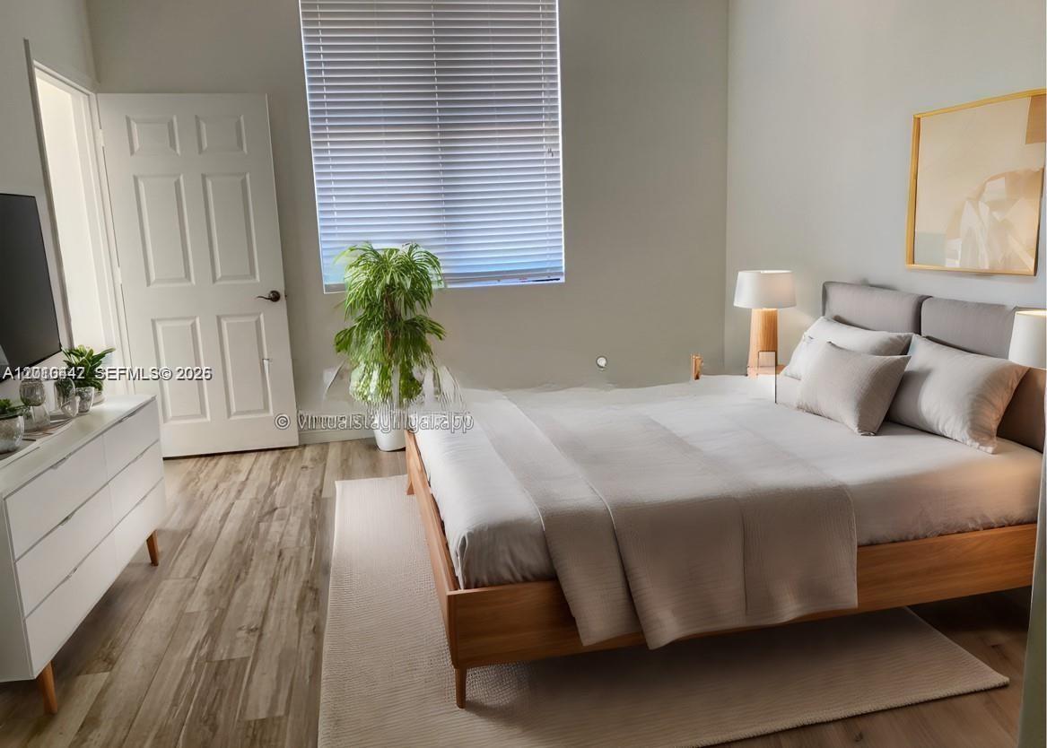 A bedroom features a wooden bed frame, white dresser, and light wood-look flooring — 888 S Douglas Rd # 1602, Coral Gables FL 33134, CORAL GABLES, FL