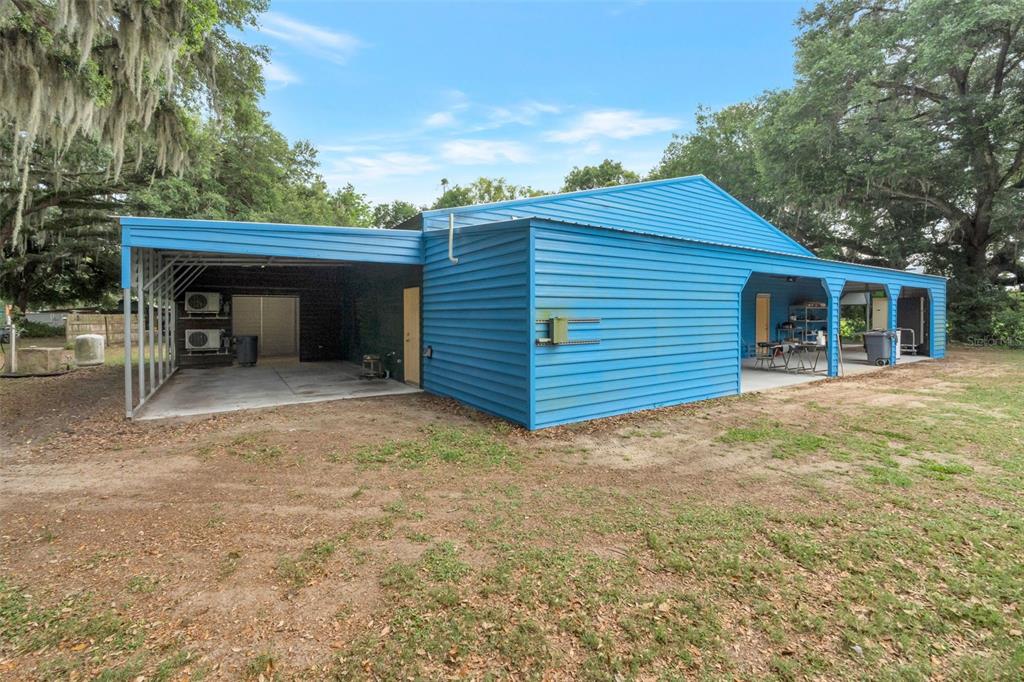 A blue metal building with a large attached carport and covered side patio area — 2102 OLD POLK CITY ROAD, LAKELAND, FL