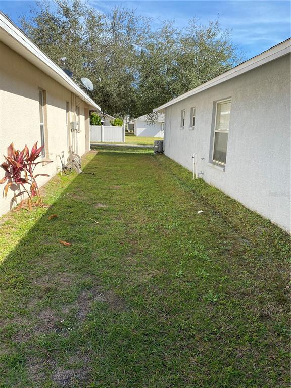 A narrow grassy side yard sits between two light-colored stucco houses — 10328 SUMMERVIEW CIRCLE, RIVERVIEW, FL
