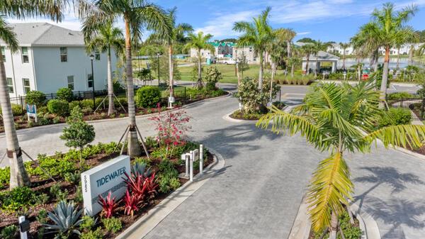 A paved entrance road leads to a residential community with palm trees and a sign — 419 Salisbury Circle, Fort Pierce FL 34982, FORT PIERCE, FL